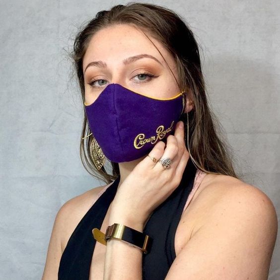 A Quinceanera woman wearing a purple face mask.
