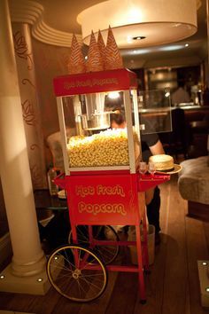 A table with a popcorn cart filled with popcorn, a Quinceanera themed image.