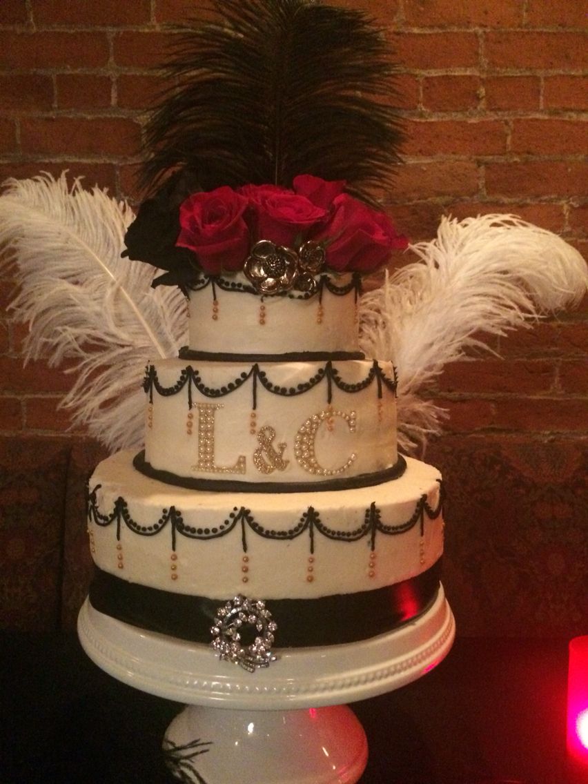 A Quinceanera cake with an old Hollywood theme. The three-tiered cake is beautifully decorated with feathers and roses.