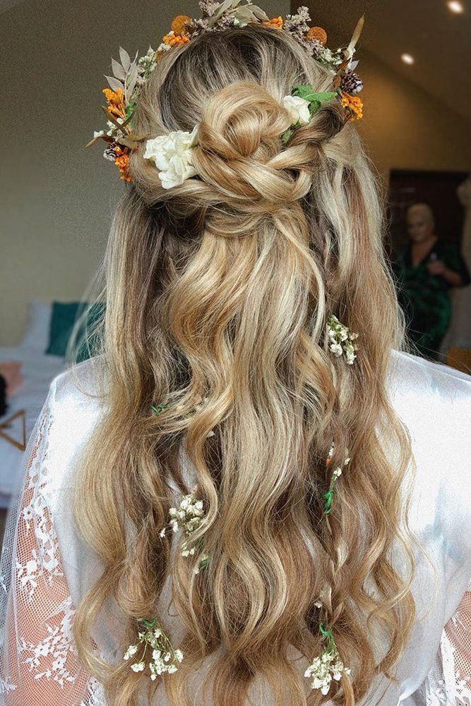 Quinceanera hairstyle of a woman with long blonde hair adorned with flowers