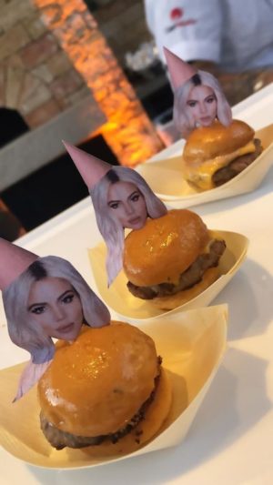 A table filled with Quinceanera-themed desserts, featuring plates of hamburgers adorned with Quinceanera photos.