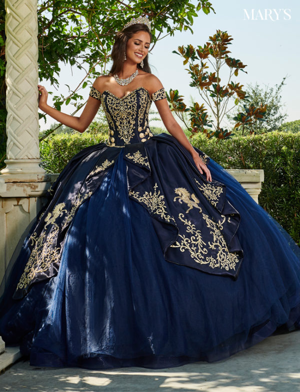 A woman in a navy blue charro quinceanera dress posing for a picture