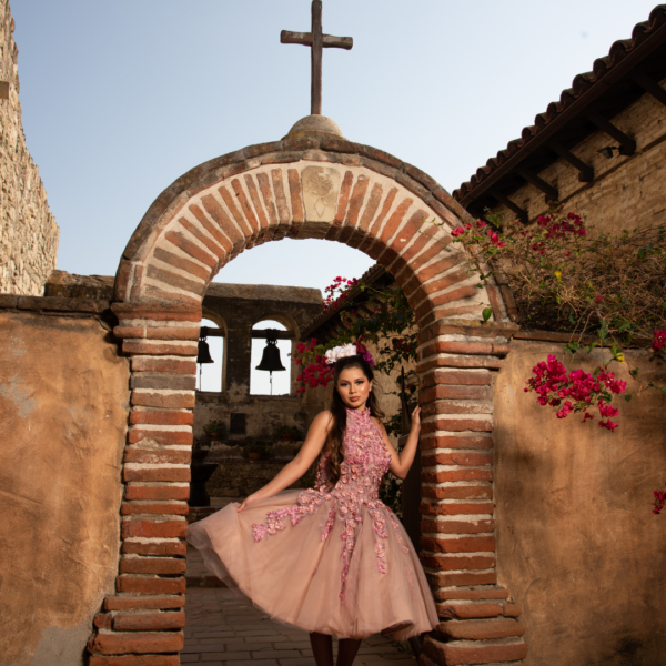 Mission San Juan Capistrano, a Quinceanera landmark, featuring a chapel, museum, and gardens with a woman in a pink dress standing in a doorway