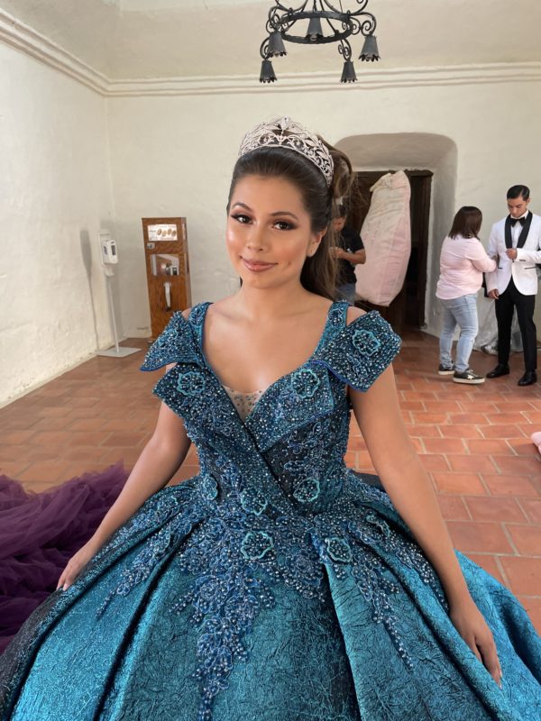 A woman in a Quinceanera gown posing for a picture