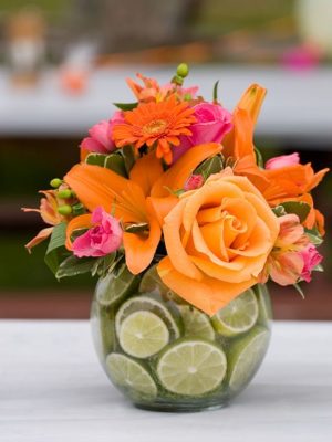 Quinceanera centerpiece, a vase filled with orange and pink flowers with a Mexican theme