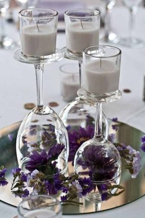 A Quinceanera mirror centerpiece with a tray featuring candles and wine glasses.
