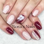 A close up of a person's nails with red and white designs, a manicure for a Quinceanera celebration