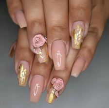 A woman's hands with a pink and gold manicure for a Quinceanera.