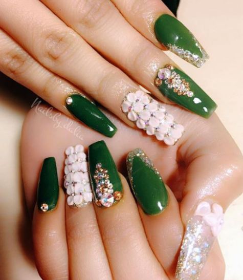 A person holding a green manicure with white flowers on it