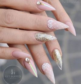 A woman's hand with pink and gold nails in a Quinceanera-themed nail manicure