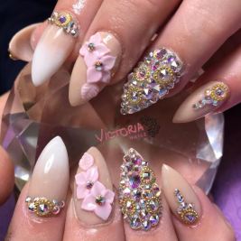 A woman holding a bottle of nail polish while getting a Quinceanera manicure