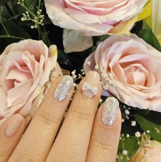 A close up of a person's hand with a ring on it, surrounded by nail Garden roses