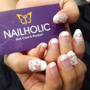A person holding a business card with a Quinceanera design on it, with a nail manicure.