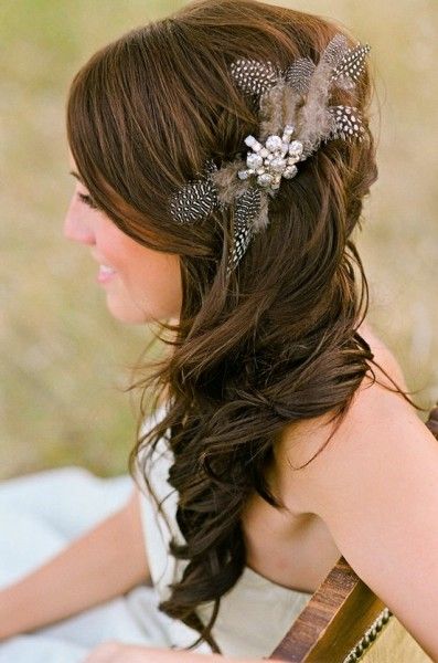 A woman sitting on a blanket with a feather in her hair, wearing a fashionable Quinceanera shoe as an accessory.