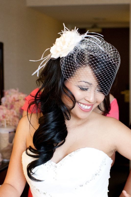 A woman in a wedding dress and a veil holding a cobalt blue high-heeled shoe