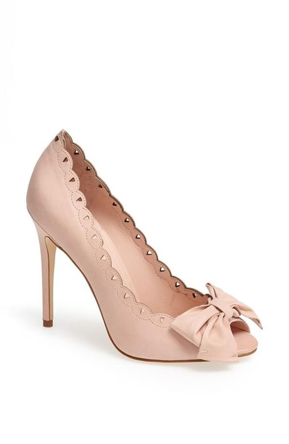 A pair of nude colored Quinceanera shoes with bows, featuring a basic pump Kitten heel.