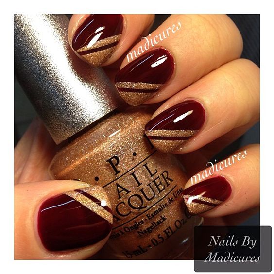 Quinceanera themed image with gold wine nail designs. The image shows a person holding a bottle of nail polish for nail art.
