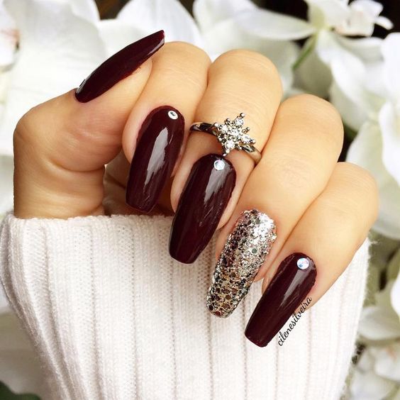 A Quinceanera-themed image showing a woman's hand with a maroon manicure and a diamond ring, showcasing nexgen nails design.
