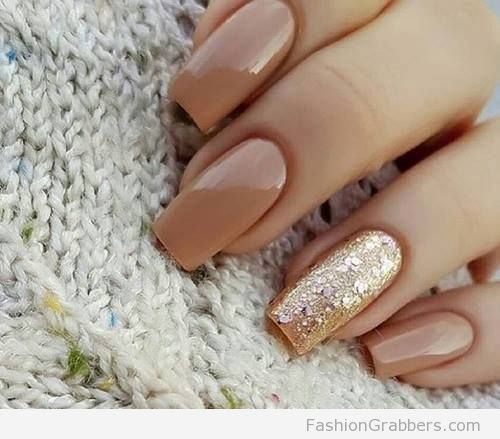 Quinceanera inspired nail designs, featuring a woman's hand with golden brown nails and a manicured manicure adorned with gold glitter