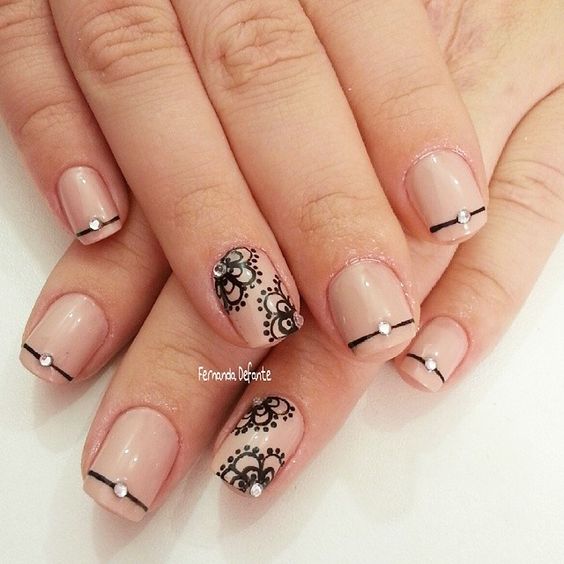 A quinceañera nail design featuring a black and white manicure on a woman's hand.