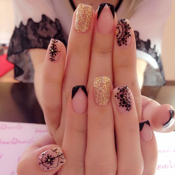 A woman with a black and gold manicure on her nails, featuring mandala nail art designs for Quinceanera