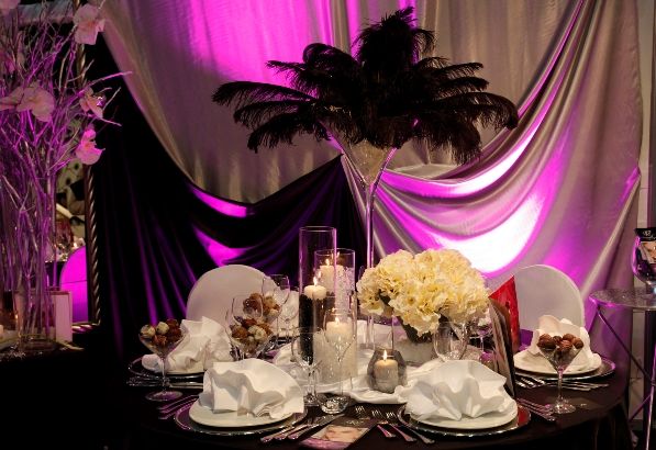 Quinceañera table decoration using candles and feathers.