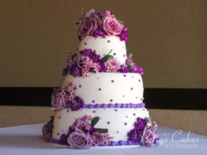 Quinceanera cake, a Quinceanera cake with purple flowers on a table