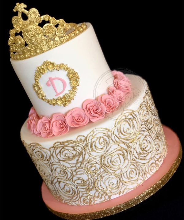 Cake decorating, a white and pink cake with a gold crown on top, perfect for a Quinceanera celebration