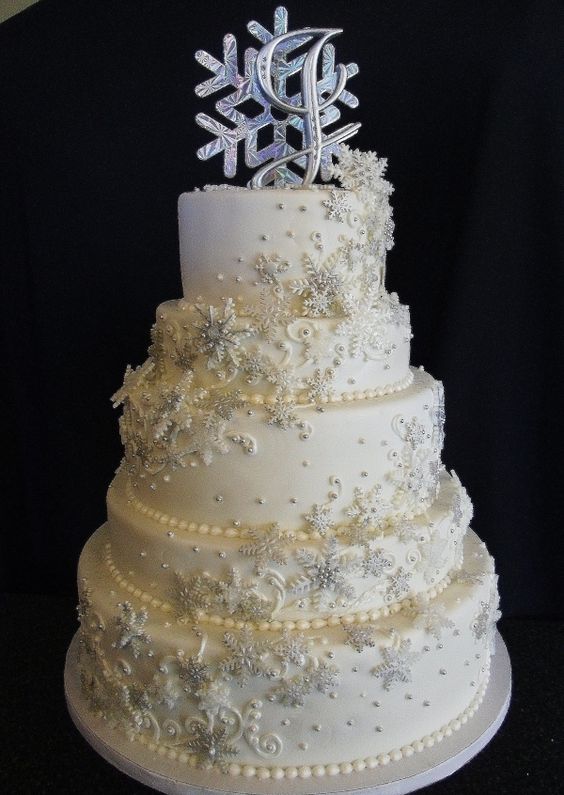 A white Quinceanera cake with snowflakes on top