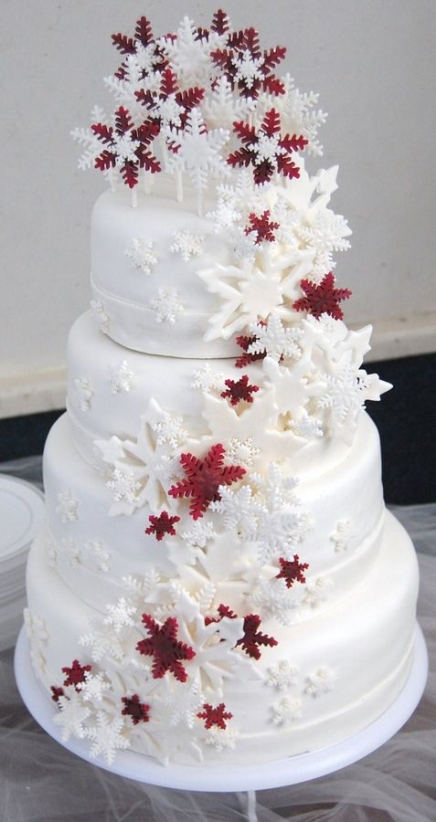 A Quinceanera themed cake, featuring a white cake adorned with red and white flowers in a Christmas theme.
