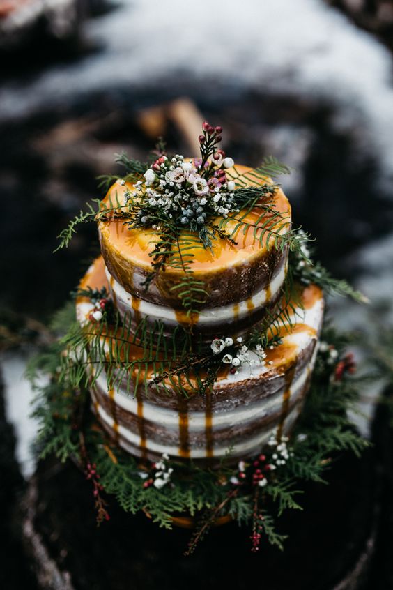 Quinceanera cake, a three tiered cake covered in frosting, decorated with pine branches and autumn leaves