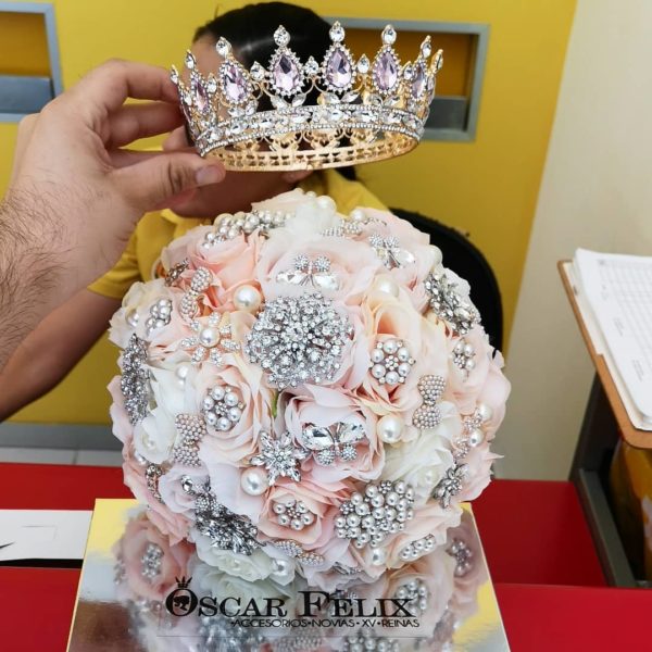 Quinceanera flower bouquet, a person holding a bouquet with a crown on top of it