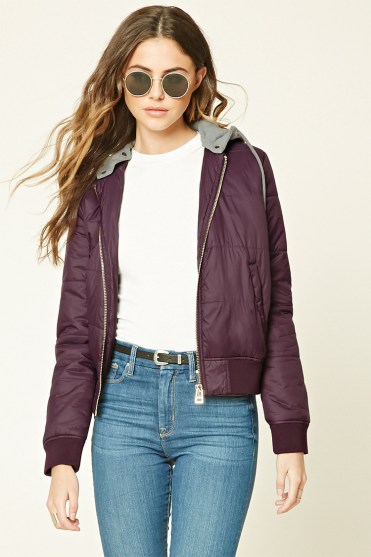 A woman wearing a purple Quinceanera jacket and jeans
