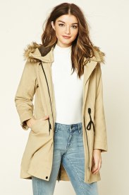 A fashion model wearing a beige parka and jeans for a Quinceanera