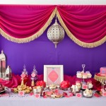 A Quinceanera celebration with a function hall party. The table is adorned with lots of desserts and pastries.