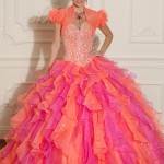 A woman in a pink and orange Quinceañera dress posing for a picture