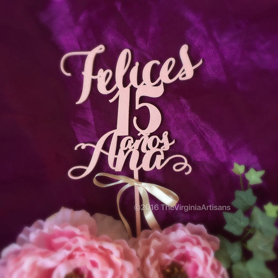 A Quinceanera cake with a topper that says 'Felices 15'. The cake has a name on it.