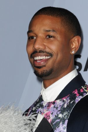 Quinceanera image: Michael B. Jordan, a man in a tuxedo, smiling at the camera with a stylish hairstyle
