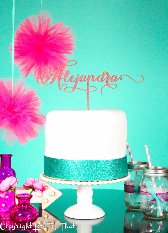 A Quinceanera cake decorated with sugar and a name on top