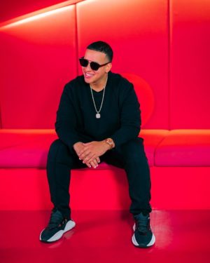 Quinceanera image featuring Daddy Yankee, a man sitting on top of a red couch