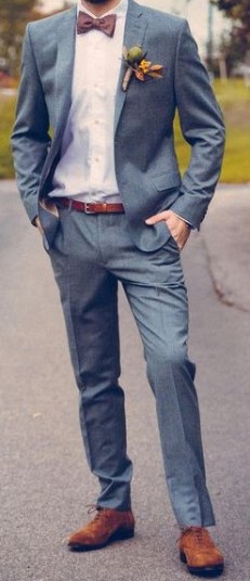 A man in a Quinceanera suit with a bow tie standing on a street
