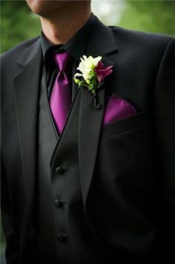 A close up of a person wearing a tuxedo suit and tie at a Quinceanera event.