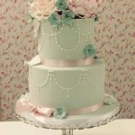 Elegant green and pink Quinceanera cake, a three-tiered cake with flowers on top