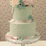 Elegant green and pink Quinceanera cake, a three-tiered cake with flowers on top
