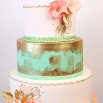 A mint and coral Quinceanera Wedding Invitation and a three-tiered cake with flowers on top