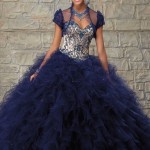 A woman in a blue Quinceañera gown standing in front of a stone wall