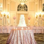 Pink sequin cake table, a Quinceanera cake on a table in front of a chandelier