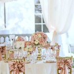 Quinceanera decoration featuring dusty rose gold accents, with a beautifully arranged table adorned with a variety of glasses and elegant flowers.