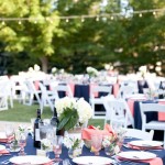 A beautifully decorated table set up for a Quinceanera celebration, adorned with navy blue and pink decorations.