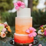 Quinceanera orange and pink cake, a three-tiered cake with flowers on a table